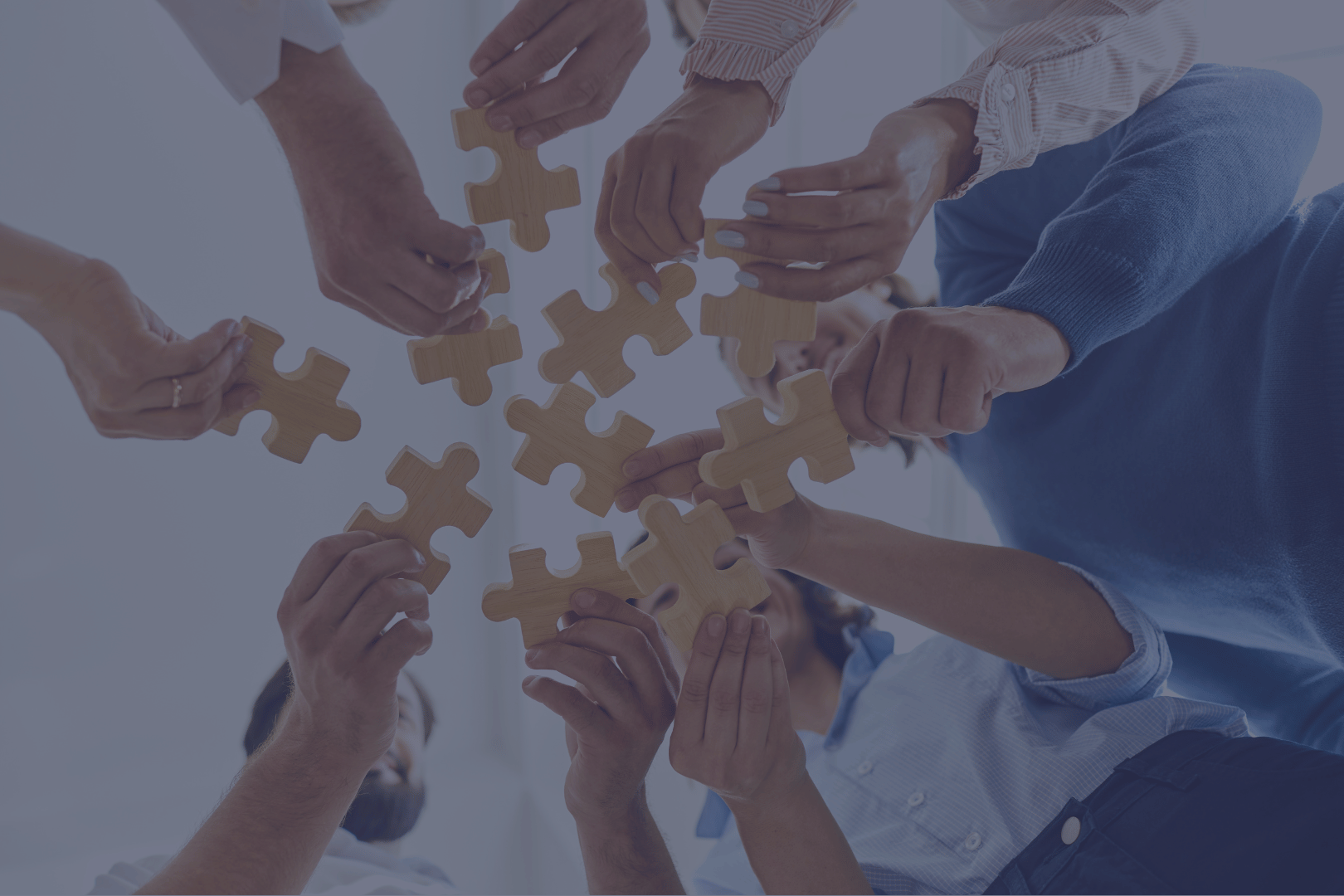 Zespół układający puzzle - metafora współpracy i dopasowywania talentów